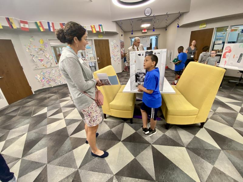 Incoming H.O.B. Assistant Principal Julie Hickman chats with second-grader Cameryn Page about his project.